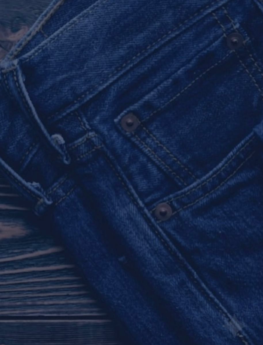 Ahşap masa üzerinde katlanmış denim pantolonlar